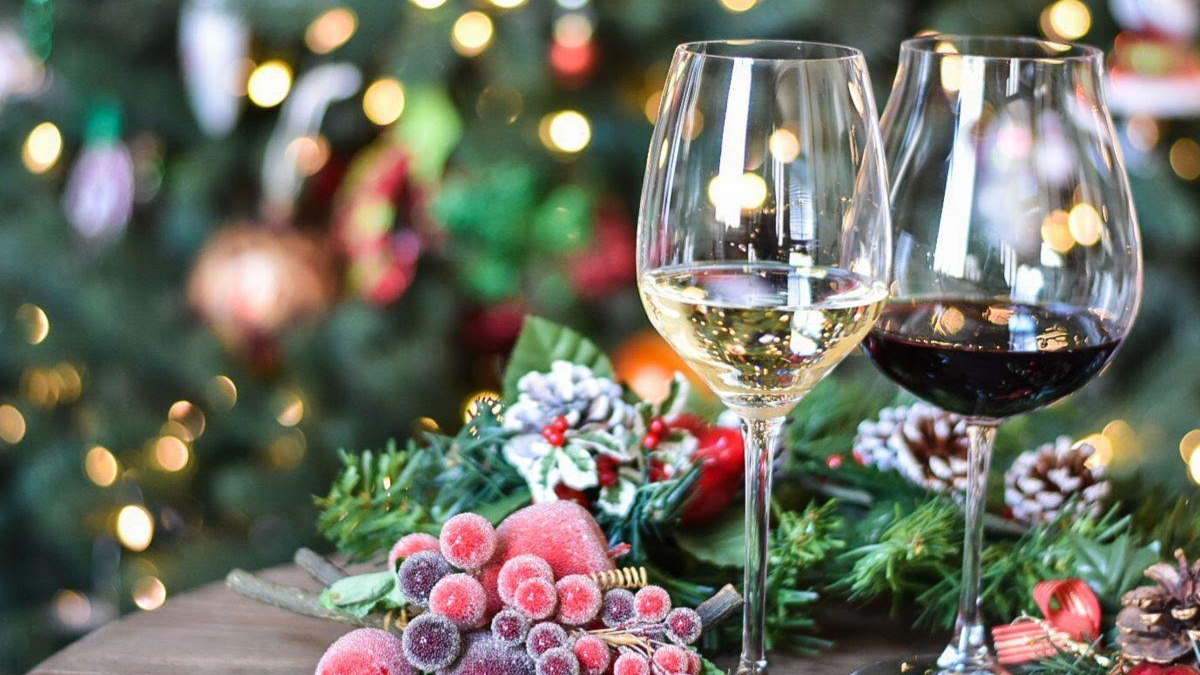 A cozy interior of a wine cellar with a leather couch, a table with a glass of champagne, and a wine rack in the background.